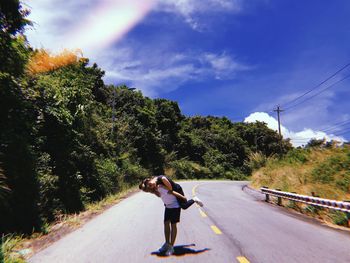 Rear view of woman on road against sky