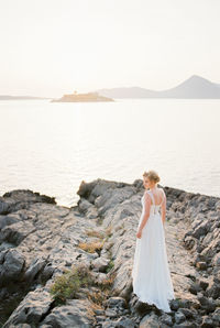 Rear view of woman looking at sea against clear sky