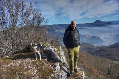 Man standing in mountains against sky during winter