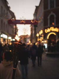 People walking on illuminated street at night