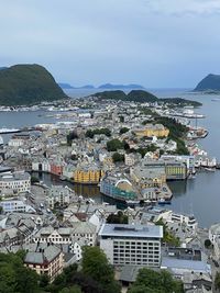 High angle view of townscape by sea against sky