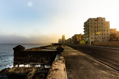 Buildings by sea against sky in city