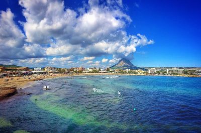 View of city by sea against sky