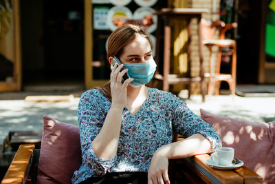 Portrait of young woman sitting in restaurant