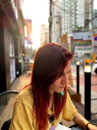 Young woman sitting at sidewalk cafe 