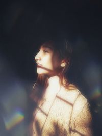 Portrait of young woman looking away outdoors