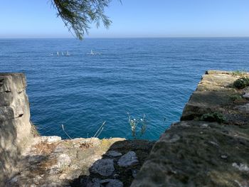 Rock formations in sea against blue sky