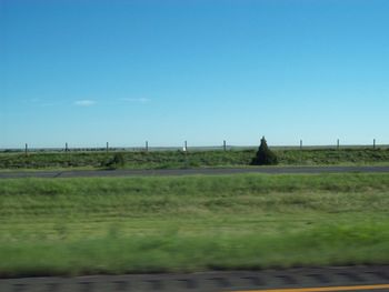 Scenic view of green landscape against clear blue sky