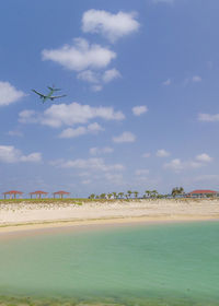 Airplane flying over sea against sky