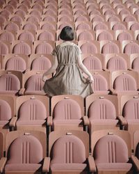 Rear view of woman sitting in chairs