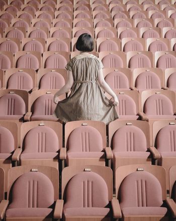 Rear view of woman standing in theater