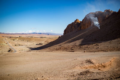 Scenic view of sand dunes against clear sky