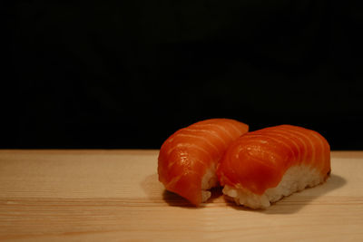 Close-up of orange on table against black background