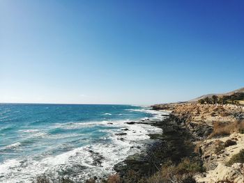 Scenic view of sea against clear blue sky