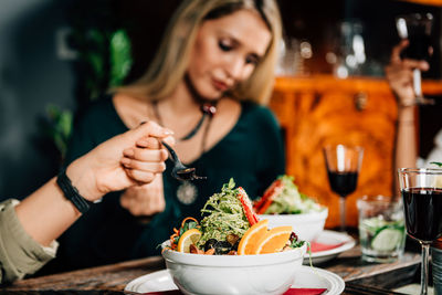Young woman eating food at restaurant