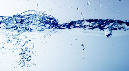 Close-up of water splashing against blue background