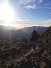 Woman standing on mountain against sky