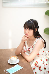 Portrait of woman with coffee cup on table