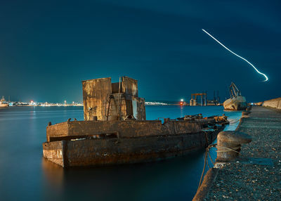 Boat moored at sea against sky at night