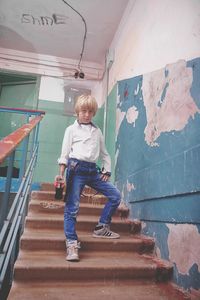 Full length of boy on staircase against wall