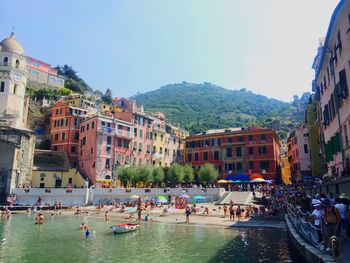 Boats in canal amidst buildings in city against sky