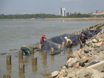 Men working with rocks at beach