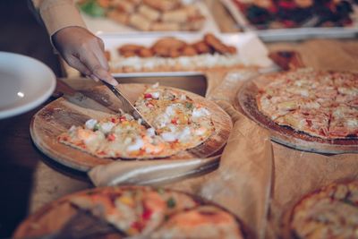 Close-up of hand holding pizza