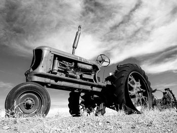 Old machinery on field against sky