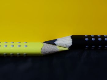 Close-up of colored pencils on yellow background