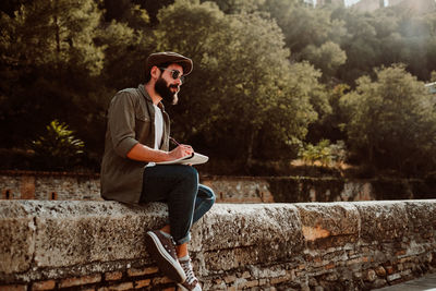 Man writing in book while sitting outdoors