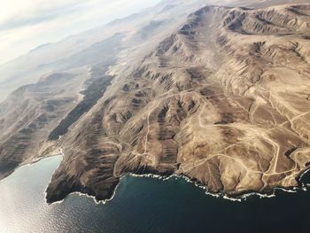 High angle view of land and sea against sky