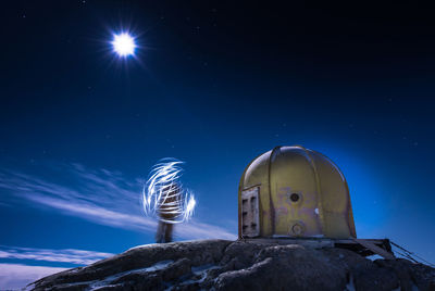 Low angle view of illuminated rock against sky at night