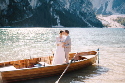 Couple standing on boat at shore