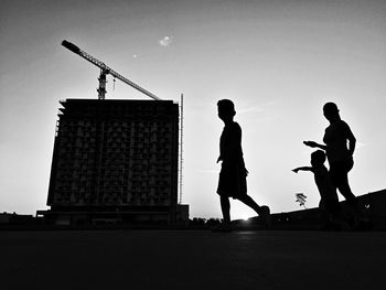 Silhouette family walking on footpath