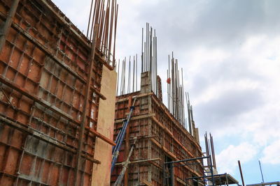 Low angle view of buildings against cloudy sky