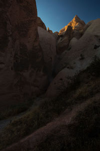 Low angle view of rocky mountains against sky