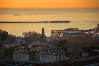 High angle view of town by sea during sunset