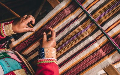 Midsection of person weaving loom