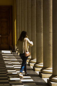 Rear view of woman walking against building