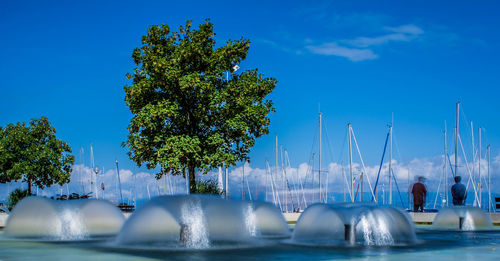 Fountain in park against blue sky