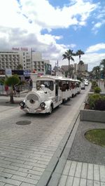 Vehicles on road against sky in city