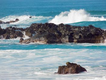 Scenic view of rocks in sea against sky