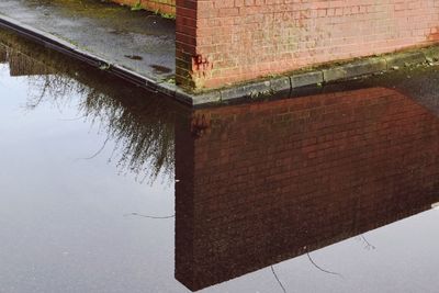 Brick wall by trees against sky