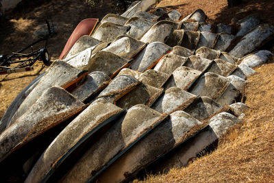 Old boats stacked on land with wear from time