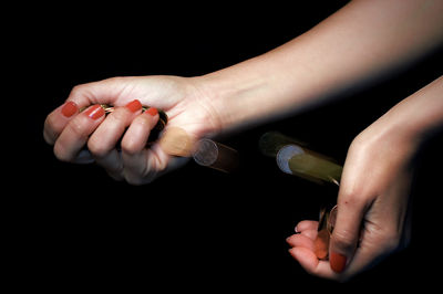 Close-up of woman hand over black background