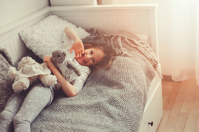 High angle view of girl lying on bed at home