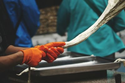 Cropped image of worker pulling taffy at factory