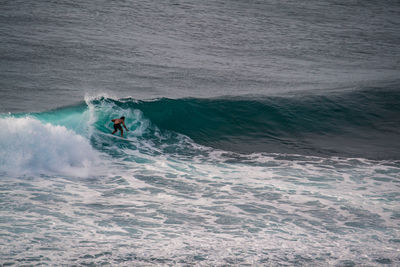 Shirtless man surfing in sea