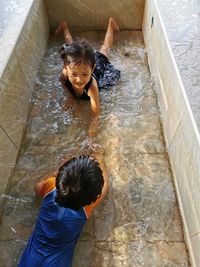 High angle view of siblings in swimming pool