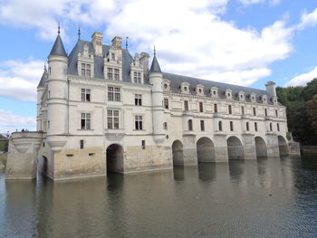 Arch bridge over river against buildings